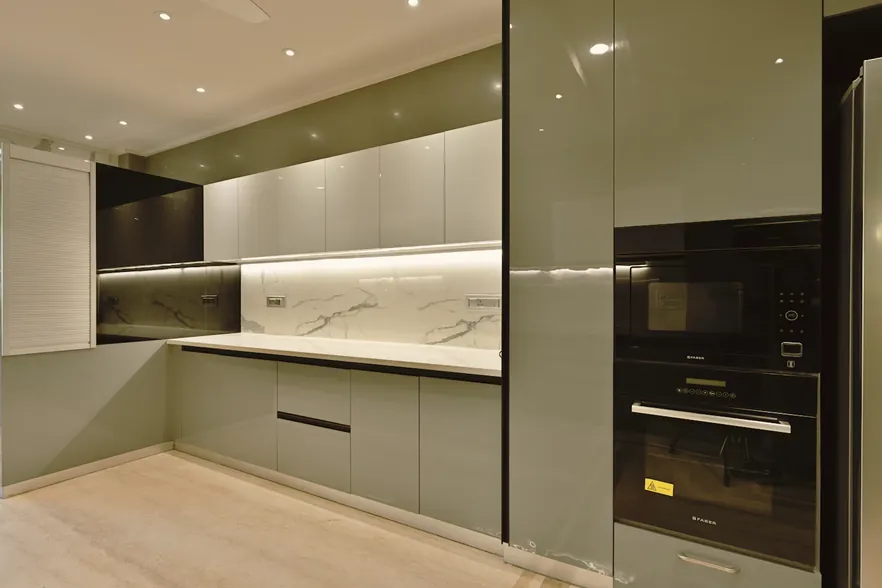 Grey high-gloss L-shaped kitchen with marble backsplash